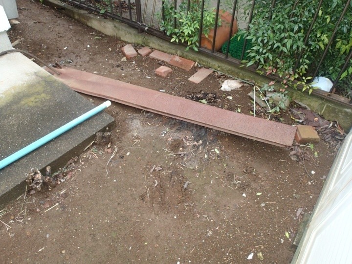 錆びた棟板金が庭に落ちている状態