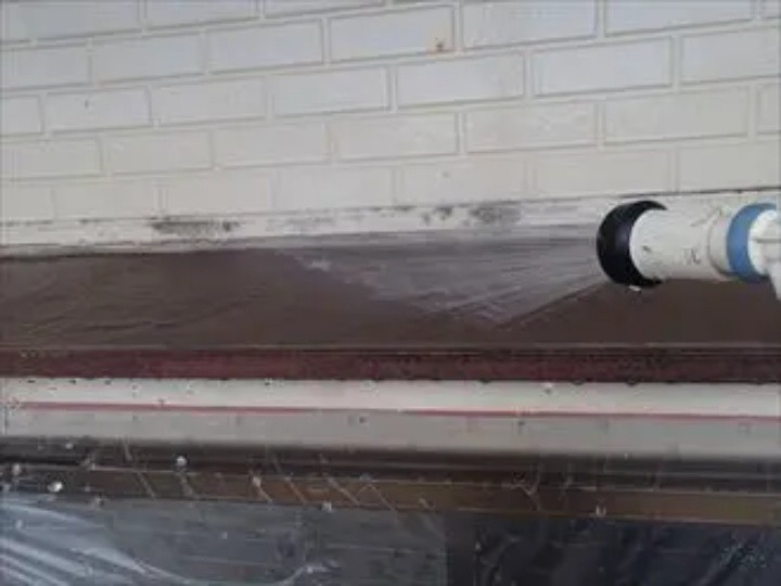 庇に散水試験する作業風景