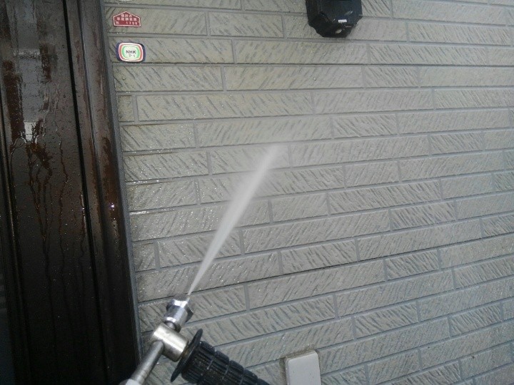 外壁に高圧洗浄する作業風景