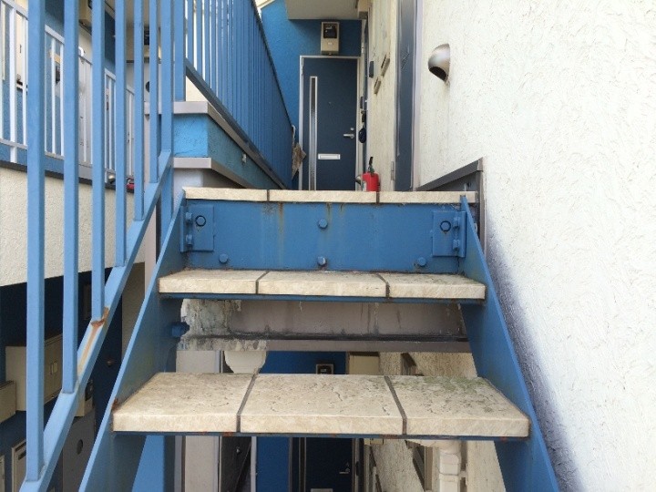 表面の青い塗料に色褪せが見られる鉄骨階段