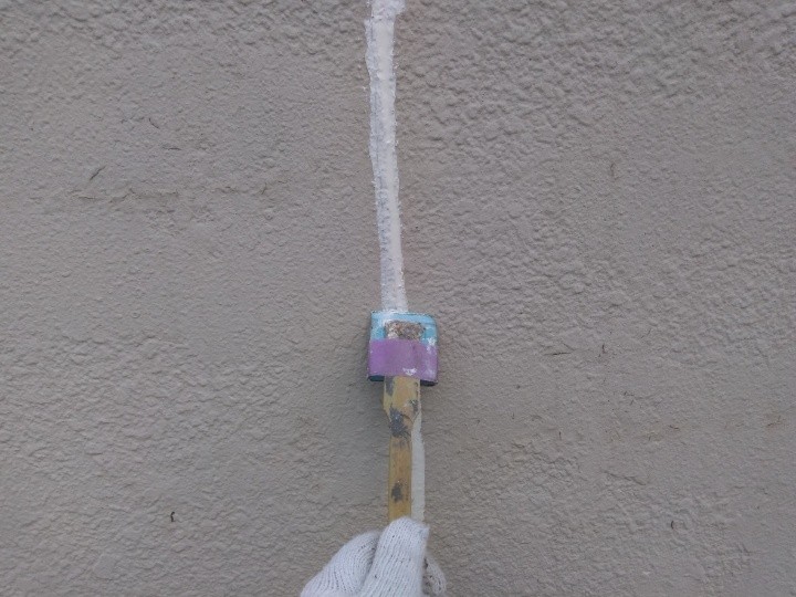 打ち込んだコーキングをヘラで均する作業