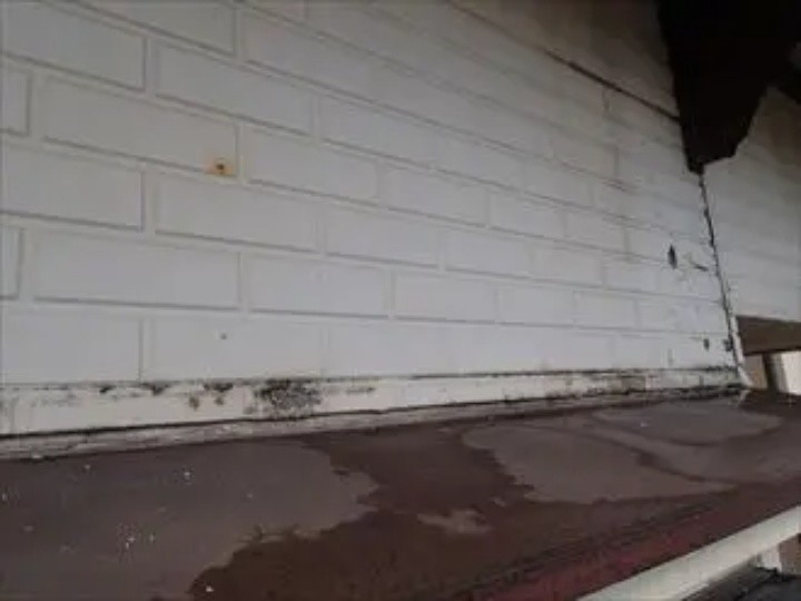 庇に散水テストする作業風景