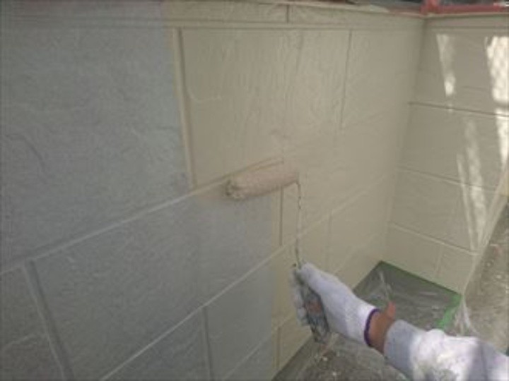 外壁に「下塗り」作業する風景