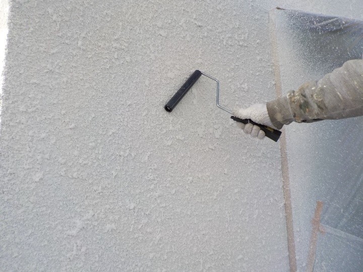 玉吹き専用の塗料がまだ半乾きの状態のときにローラーで押さえる作業風景