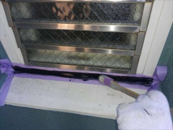 窓枠にコーキング処理する作業風景