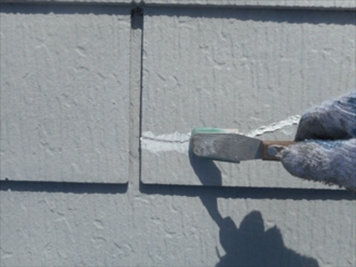 打ち込んだシール材にヘラで表面を均する作業