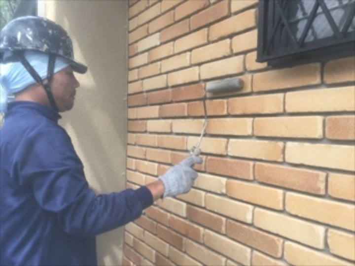 玄関周りのタイル壁に塗料を塗布する作業工程