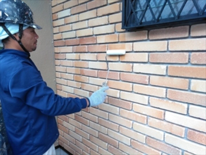 玄関周りのタイル壁に透明の専用塗料を塗布