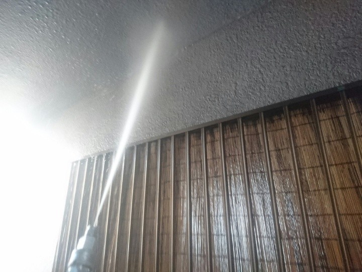 外壁に高圧洗浄する作業風景