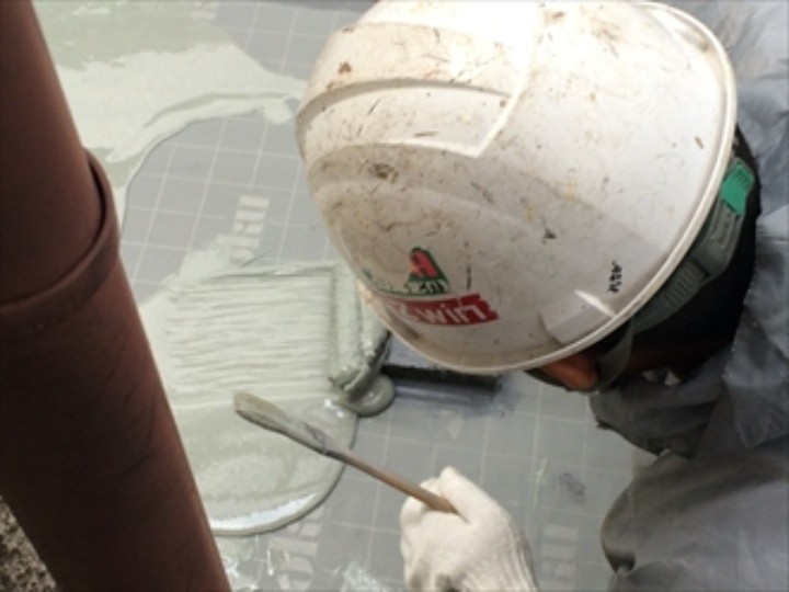 床面に塗布したウレタンをヘラで整える作業