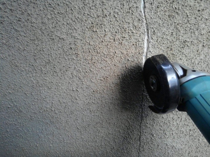 外壁の亀裂にサンダーで切り込みモルタルを充填しやすい形状に