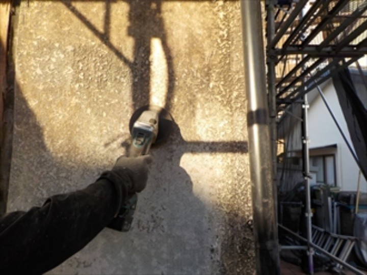 サンダーを使って表面を削り荒れた部分を整える作業