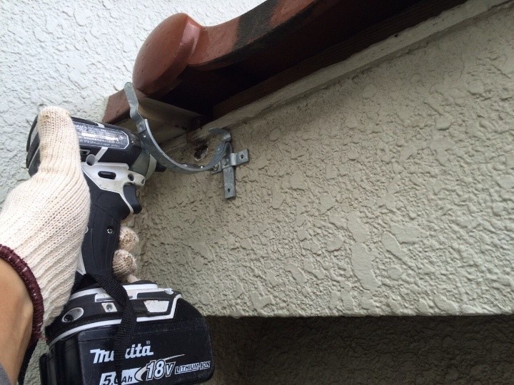 新しい雨樋を取り付けるための金具を順に設置する作業