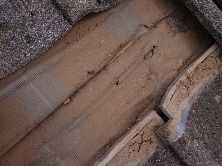 瓦をめくると露出した傷んだ防水紙