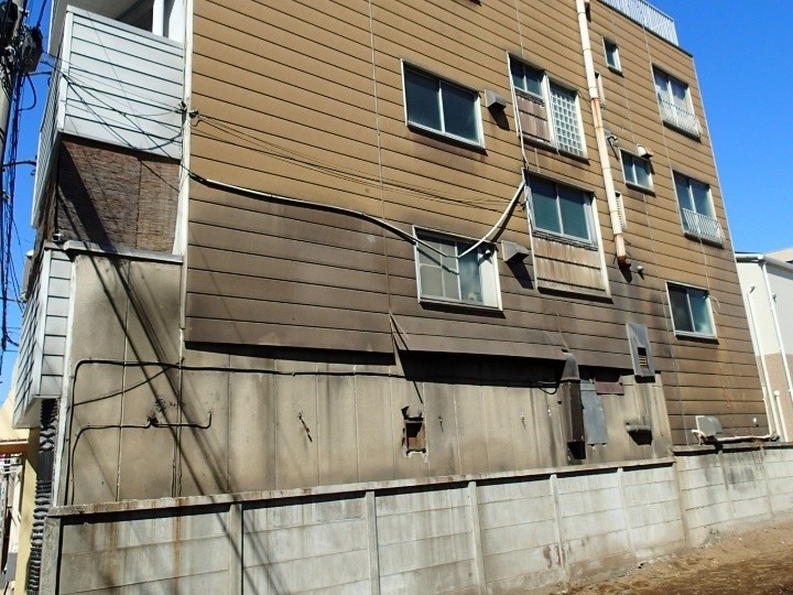 剥がれと変形が目立つ外壁の状況