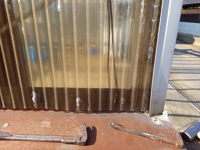 カーポート側壁の波板をバールで取り外している状況