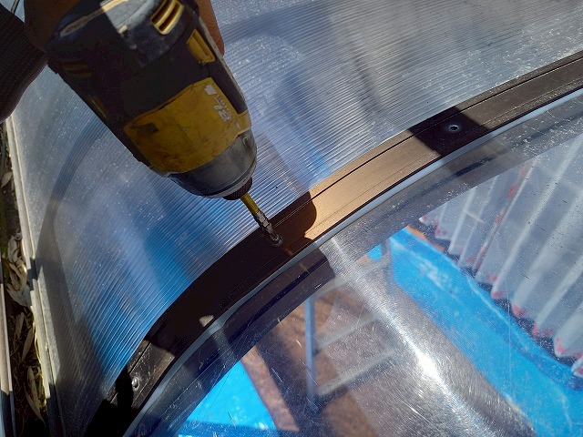 サンルームポリカ屋根張り替え修理でフレームのビスを外している様子