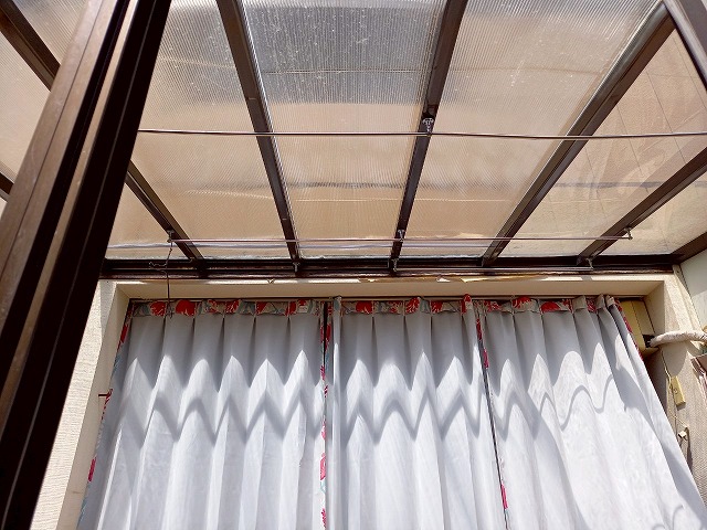 落雪で割れてしまったサンルームの屋根に別の屋根材を仮設置している状況