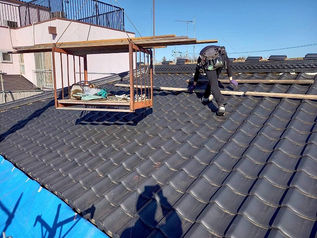 屋根葺き直し工事で瓦屋根に引っかける足場を設置している様子