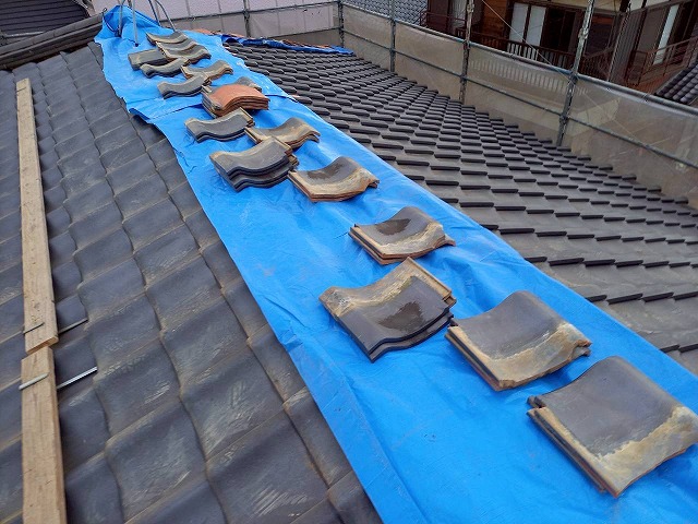 屋根葺き直し工事の棟部解体後にブルーシートで雨養生を施した状況