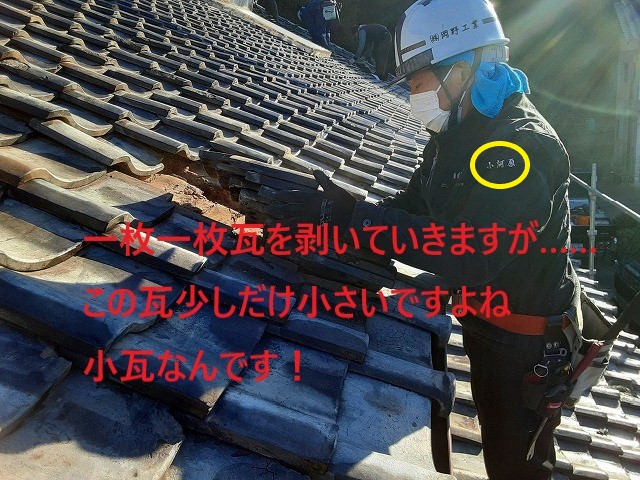 土葺き屋根の瓦を下ろしていくスタッフ
