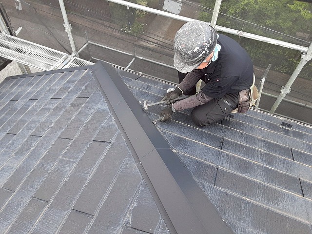 屋根カバー工事で既存棟板金の釘を抜いている様子