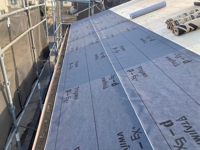 屋根葺き替え工事で改質アスファルトルーフィングを軒先から施工している様子