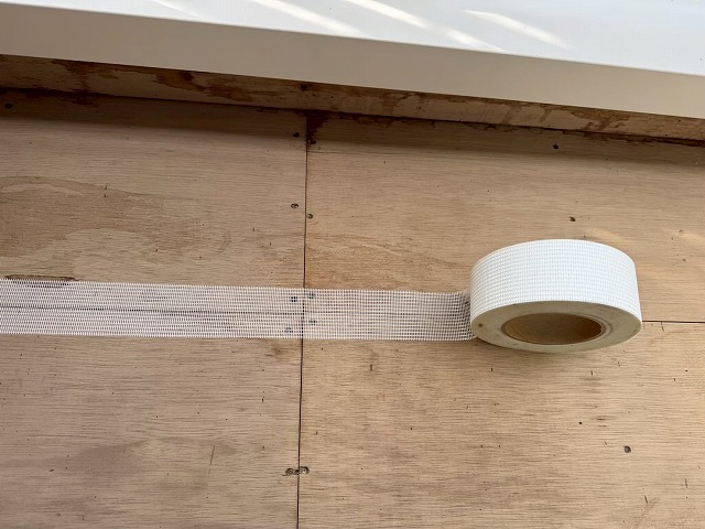 ウレタン塗膜防水工事の合板下地目地部へのメッシュテープ貼り付け状況