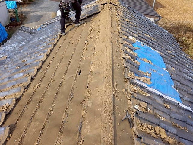 瓦屋根葺き替え工事で既存瓦を解体している屋根職人