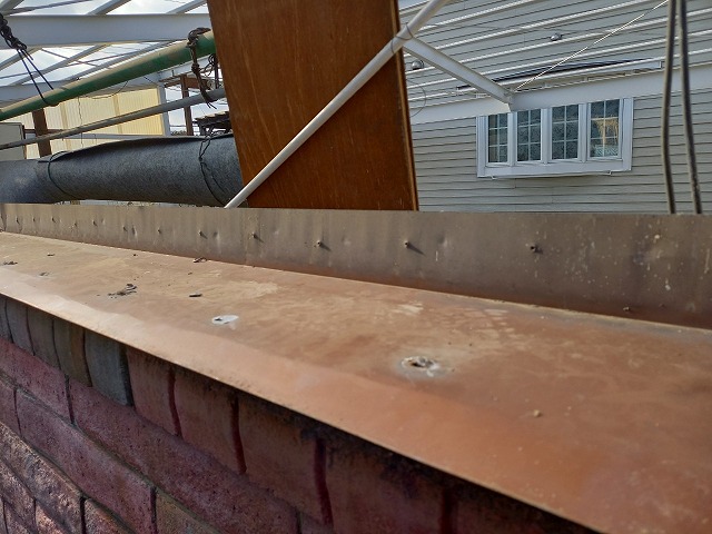 レンガ塀の天端に設置されている水切り板金の劣化状況