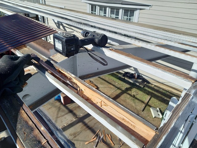 雨水の影響を受けて傷んでいたカーポート屋根の木下地の一部をバールで除去