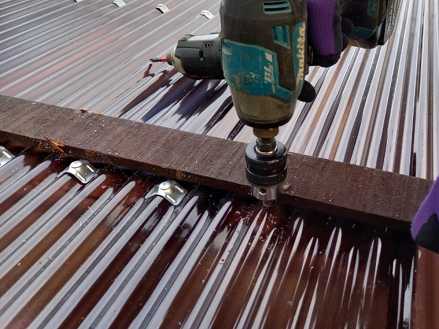 住宅カーポートポリカ波板張り替え工事で波板に下穴をあけている様子