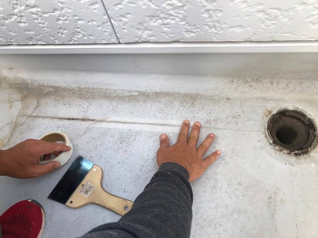 ベランダ防水メンテナンス下地処理工程のひび割れへのメッシュテープ貼り
