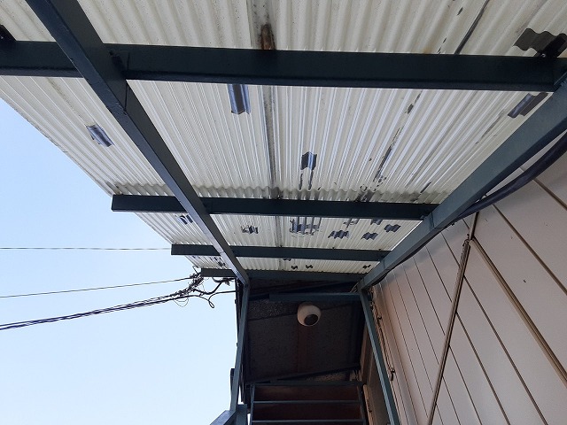 物置建物の外部階段の波板屋根に簡易的な補修跡