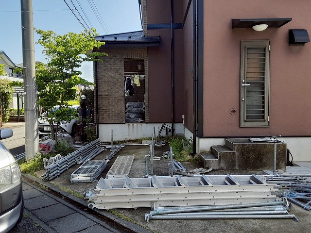 屋根カバー工事を行うための足場の資材を降ろしている状況