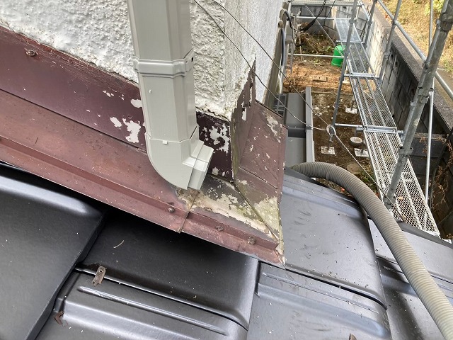 雨樋交換工事で雨押え板金の上に竪樋を落とした状況