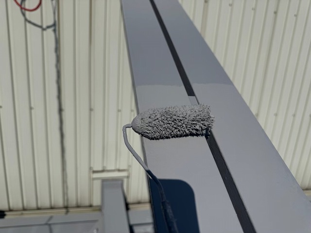 倉庫建物屋根鉄骨塗装工事のアクリルシリコン樹脂塗料を用いた上塗り施工