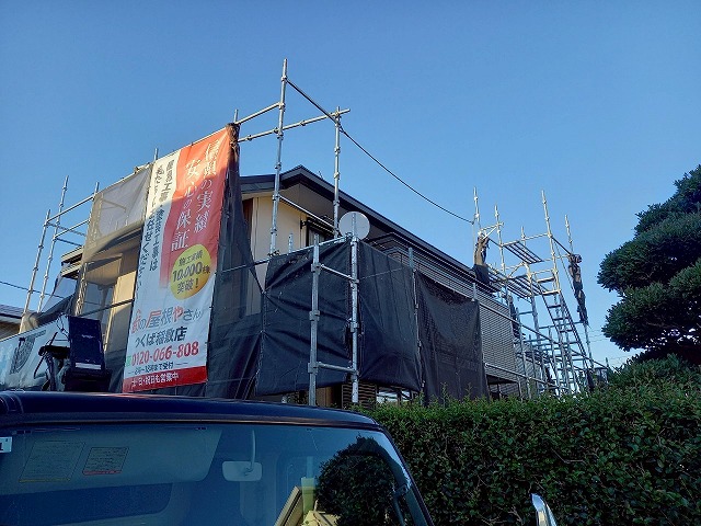 屋根カバー工事を行うための足場へメッシュシートを張っている状況