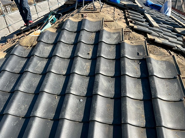 屋根葺き直し工事で平部の既存瓦材を解体している様子
