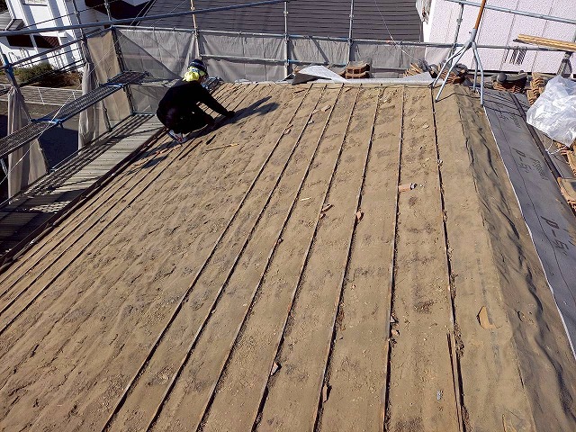 屋根葺き直し工事の瓦桟の取り外しを行う屋根職人