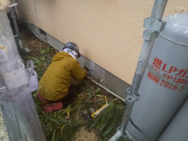 住宅基礎の化粧モルタルひび割れ部分を補修している様子
