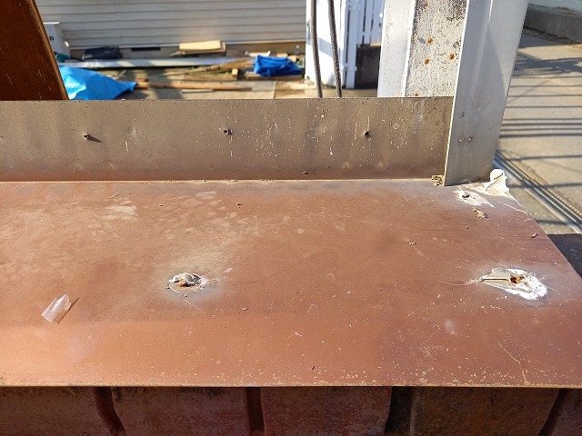 レンガ塀の天端に設置されている水切り板金のサビやコーキング劣化