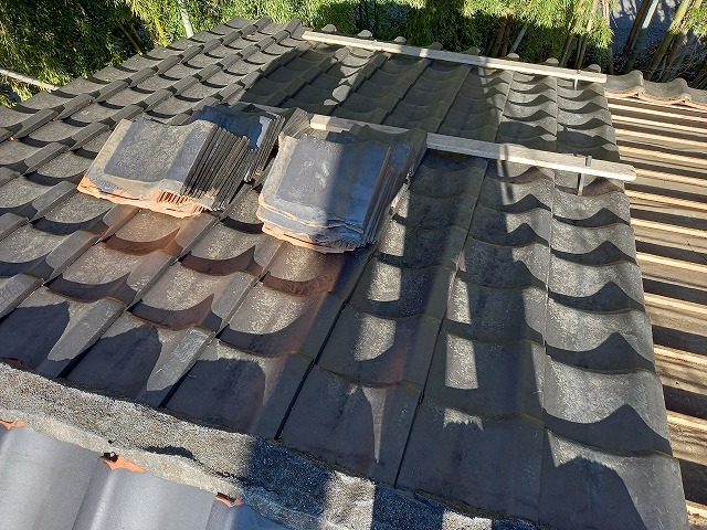 倒木による損傷を受けた住宅屋根の瓦を取り外して仮置きしている状況