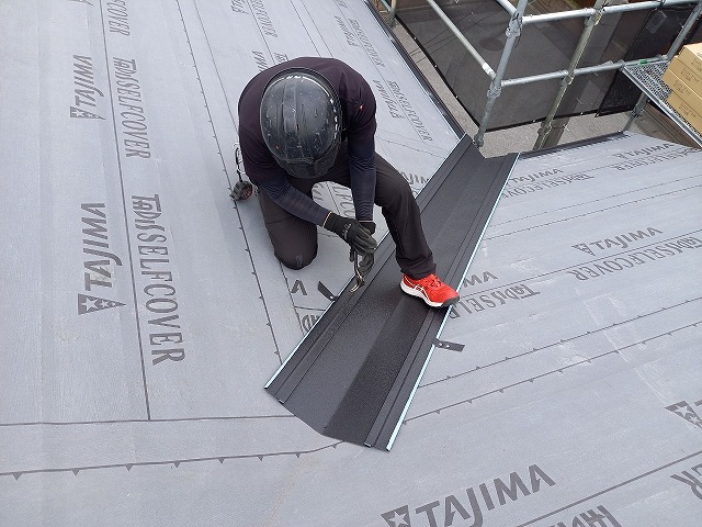 屋根カバー工事で谷樋を吊り子で固定している様子