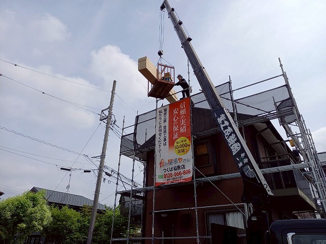 屋根カバー工事で使用する屋根材をユニック車で荷揚げしている様子