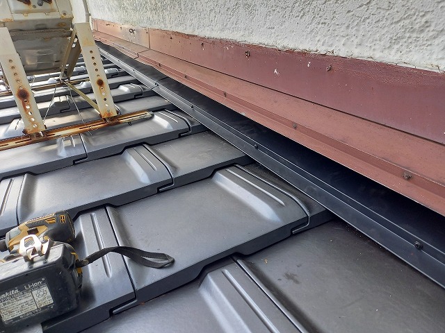 屋根葺き替え工事の下屋根と外壁との取り合い部に雨押え板金を取り付け