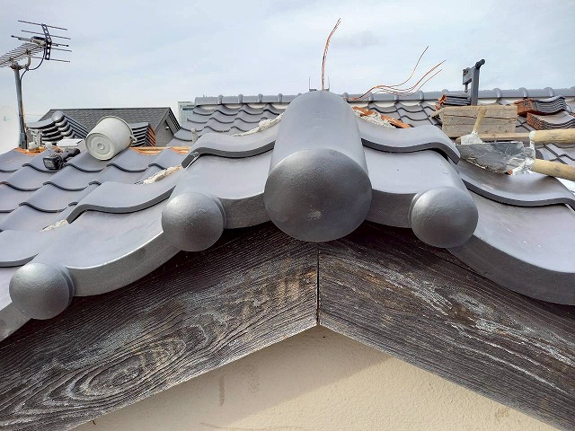 屋根葺き替え工事の掛瓦頂上部への巴瓦設置
