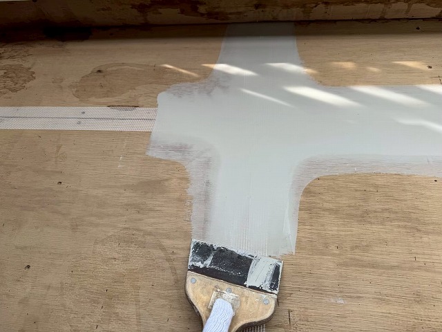 ウレタン塗膜防水工事の合板下地目地部へのパテ塗り付け状況
