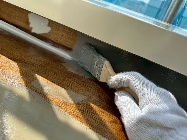 ベランダ防水工事で立ち上がり部分へウレタン防水材を塗布している様子