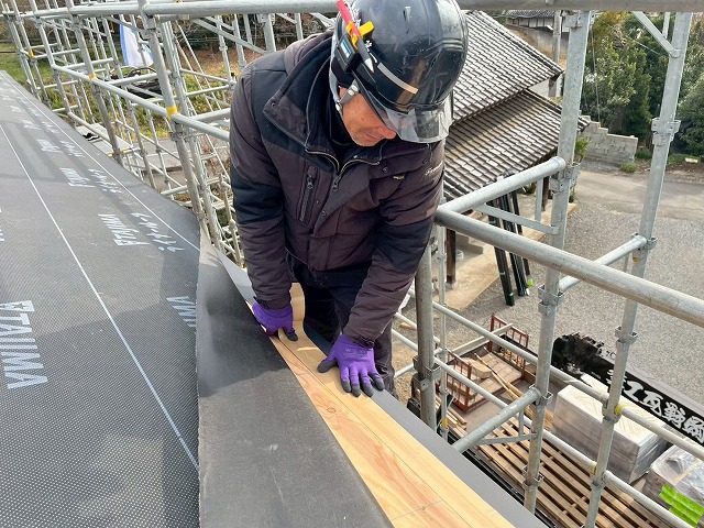 屋根仕上げ工事で軒先水切と野地板との取り合い部に防水テープを貼り付け